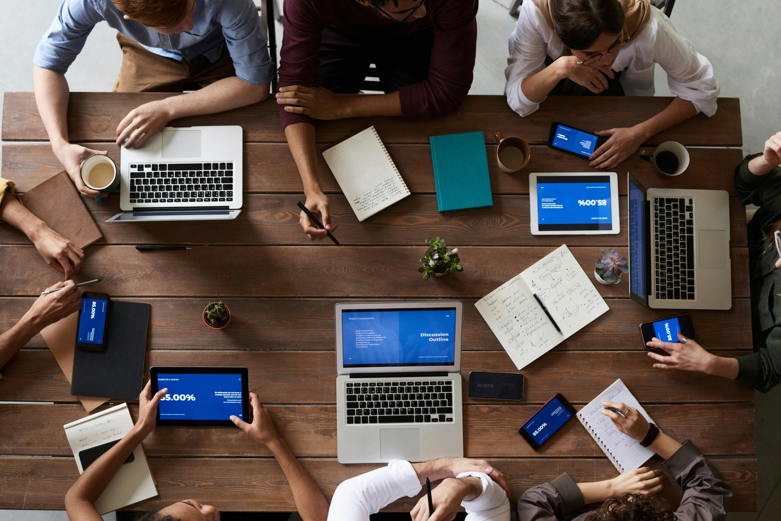 Home Overhead view of a diverse team in a business meeting using laptops and tablets.